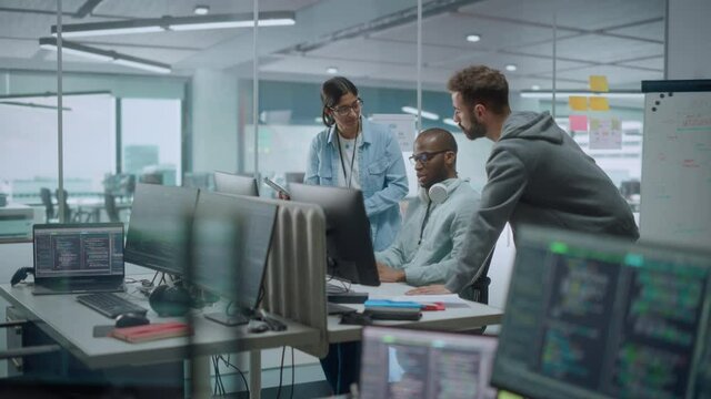 Diverse Group of Professionals Meeting in Modern Office: IT Programmers Use Computer, Talk Strategy, Discuss Planning. Specialists Create Innovative Software. Engineers Develop Inspirational App