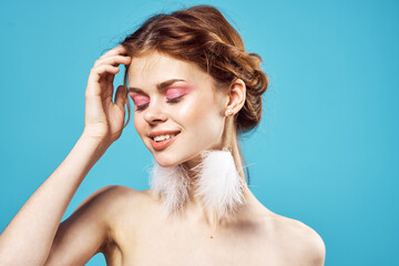 woman with bare shoulders and fluffy earrings fashion fun cosmetics