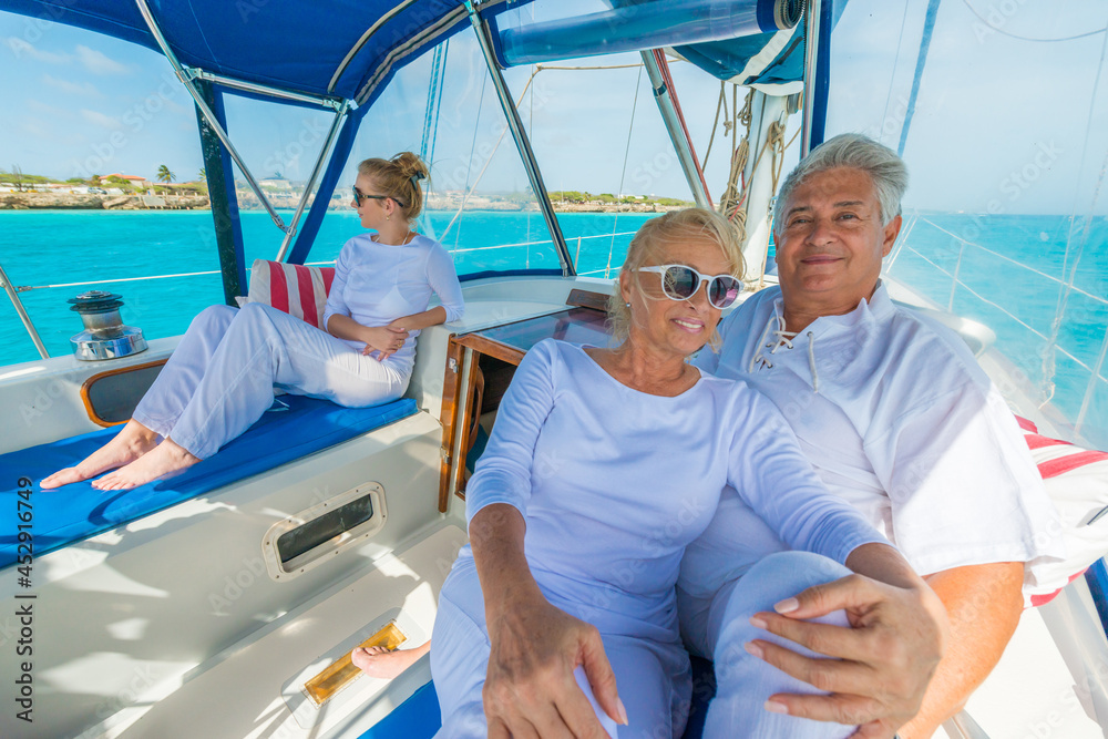 Wall mural Senior couple, enjoying sailing trip on a luxury summer holiday vacation, sunny weather and ocean in background, love and romance on a beautiful yacht