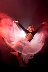 ballerina with a white dress and black top posing on red smoke background