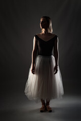 ballerina with a white dress and black top posing on gray background. © Nikola Spasenoski