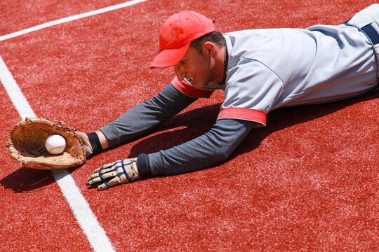 Baseball Player Diving To Catch The Ball