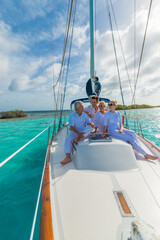 Senior and young couples, family, enjoying sailing trip on a luxury summer holiday vacation, sunny weather and ocean in background, love and romance on a beautiful yacht