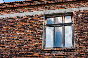 Window in red brick wall of the ancient residential building