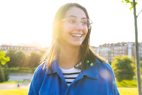 Content woman in stylish outfit on hill in city