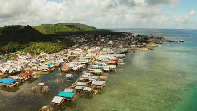 Village of stilt houses built over the sea, top view. Dapa, Siargao, Philippines.