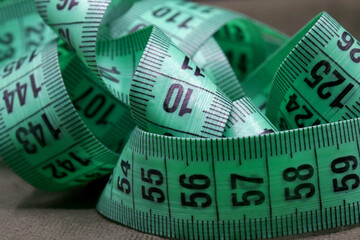 green measuring tape on fabric background