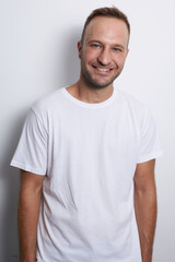 Man smiling in a white background with white t-shirt