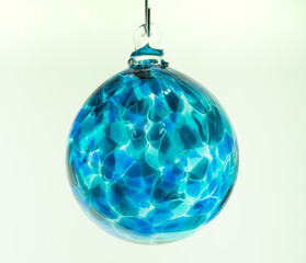 Glass bauble.  Single hand blown glass Christmas tree ornament in clear translucent aqua blue on a...
