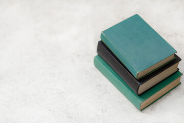 Stack of Blue Vintage Books on White Marble Background With Copy Space