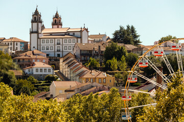 Viseu Cathedral in the background with the Ferris wheel at the São Mateus fair in the foreground - obrazy, fototapety, plakaty