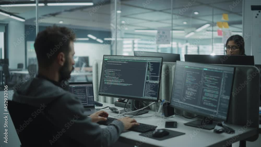 Leinwandbilder Diverse Office: IT Programmer Working on Desktop Computer. Male Specialist Creating Innovative Software Engineer Developing App, Program, Video Game. Terminal with Coding Language. Over Shoulder