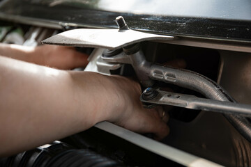 a man repairs a car. a man in blue special clothes to repair the car. engine parts machine repair...