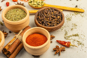 A set of spices for cooking curry. Aromatic condiments on light stone concrete background