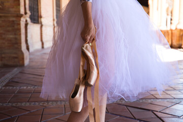 detail of ballet dancer's hands holding shoes with her hands. Classical ballet