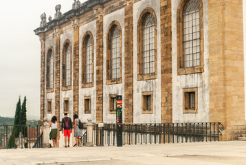 Obraz premium Tourists near the entrance of the Joanina Library at the University of Coimbra Square going down the stairs cloudy day - Portugal