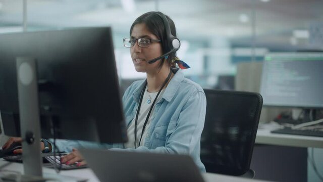 Call Center Office: Portrait of Friendy Indian Female IT Customer Support Specialist Working on Computer, Talking with Clients, Solving Problems, Finding Software Solutions, Helping to Choose Products