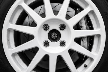 The detail of a wheel of a rallye car with part of the rim, brake caliper and brake disc visible....