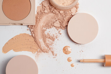 Set with Crushed beige face finishing, bronzing and liquid serum powder and tools isolated on white background. Macro texture of make up. 