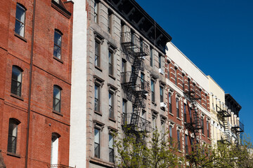 Fototapeta premium Row of Colorful Old Brick Apartment Buildings with Fire Escapes in the East Village of New York City