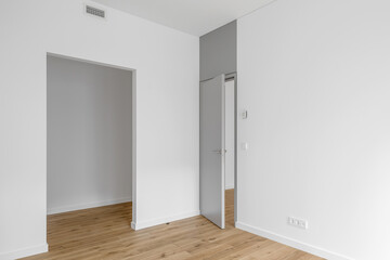 Empty minimalist modern room with white walls, opened grey door and oak wood floor