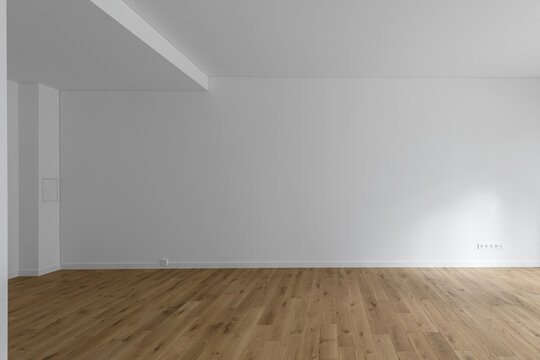 Empty minimalist modern room with white walls and oak wood floor