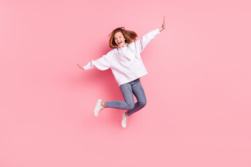 Full length body size view of attractive funky girlish cheerful trendy girl jumping good mood isolated over pink pastel color background