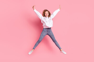 Fototapeta na wymiar Photo of adorable charming school girl wear white hoodie smiling jumping high like star isolated pink color background