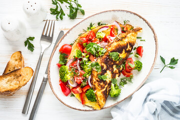 Omelet with fresh vegetables - broccoli, tomatoes and paprika. Healthy breakfast. Top view image.