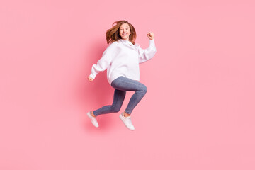 Photo of pretty adorable small schoolgirl dressed white sweatshirt jumping high running fast isolated pink color background