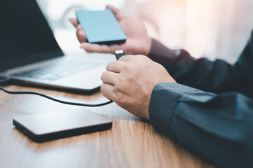 A man connect USB cable with Harddisk-External for backup data from laptop computer : protection Security data concept