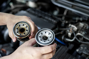 Close up used oil filter in hand a man compare with the new oil filter service concept of oil in...