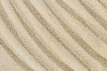 Fototapeta na wymiar Lines drawing on sand, beautiful sandy texture. Spa background, concept for meditation and relaxation