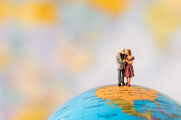 Miniature people Family Father Mother and Children standing on Global world map with happiness using for travel around the world business trip traveler adviser agency or online world wide marketing 
