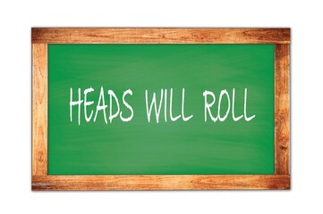 HEADS  WILL  ROLL text written on green school board.