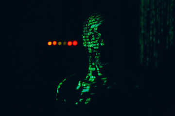 Young man with geen abstract letters on his face in the dark