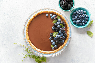 Dark chocolate mousse tart decorated with fresh blueberries and mint - obrazy, fototapety, plakaty