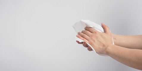 Hand is wiping tissue paper on white background.