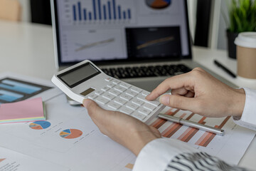 An accounting scholar is pressing a calculator, she is calculating the numbers shown on the company's income statement and financial documents, she is a company auditor. Audit concept.