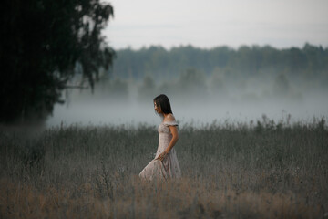 Girl in the fog. Summer fog in nature and a girl.