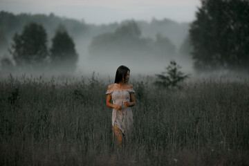 Girl in the fog. Summer fog in nature and a girl.