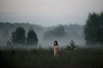 Girl in the fog. Summer fog in nature and a girl.