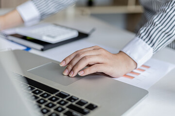 Close-up A businesswoman working in a private room, She is using a touchpad on her laptop, she uses a messenger to chat with a partner. Concept of using technology in communication.