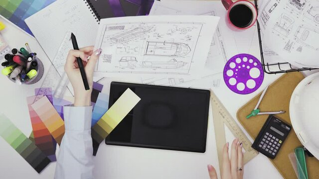Top view of a creative designer using a graphic tablet while working at his desk