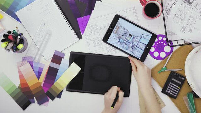 Top view of a creative designer using a graphic tablet while working at his desk