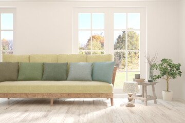 Stylish room in white color with sofa and autumn landscape in window. Scandinavian interior design. 3D illustration