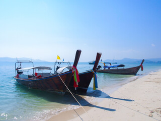 Fototapeta na wymiar Thai local long tail boats docking on the beach in summer with clear sky