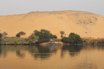The beautiful nature mix of sandy hills and plants and river in Aswan in Egypt