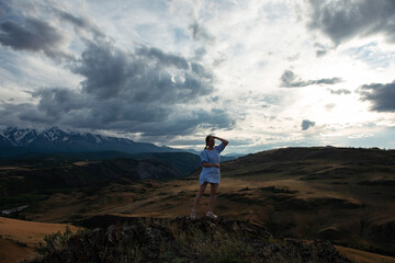 Fototapeta premium Woman in blue dress in summer Altai mountains in Kurai steppe