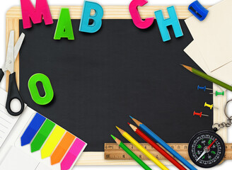 Black chalkboard with colorful school supplies as frame with copy space on white